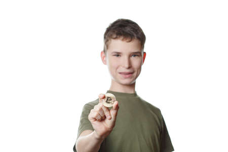 boy holds a coin bitcoin on a white isolated background, a schoolboy in school uniform, a child plays in a businessmanの写真素材