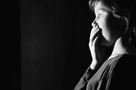 Child open door and bright lit illuminate him. Surprised girl saw something. Door to knowledge..black and white.の写真素材