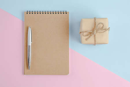 notebook with a spring on a colored background of blue and pink. office table top view