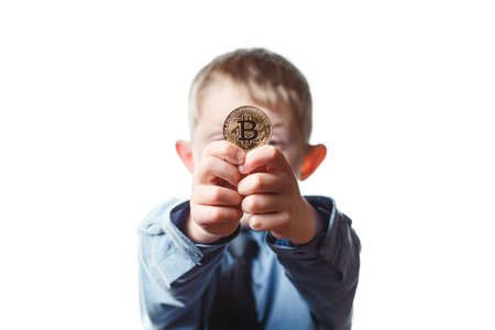 boy holds a coin bitcoin on a white isolated background, a schoolboy in school uniform, a child plays in a businessmanの写真素材