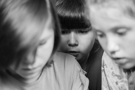 enthusiastic group of children watching a cartoon on their mobile, friends are worried about the main character of the film, close-up.black and white.の写真素材