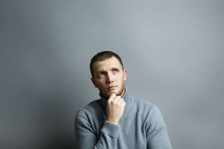 Man thoughtfully put his hand to his chin. Pensively looking to the side. Thinking about something....