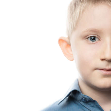 little boy looking at camera on an isolated white background in shirt. fair-haired beautiful child with blue eyesclose-up. lot of advertising spaceの写真素材