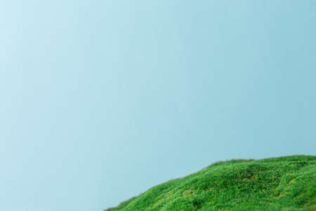 Green grass hill on a blue sky background. Spring concept with green nature moss.の写真素材
