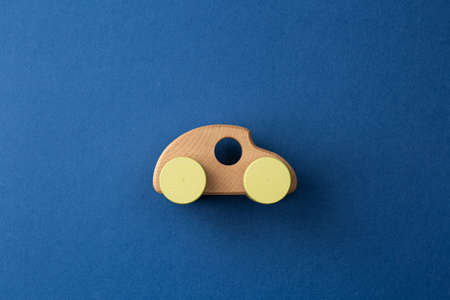 Wooden car. Environmentally friendly childrens toy on a blue isolated background.の写真素材