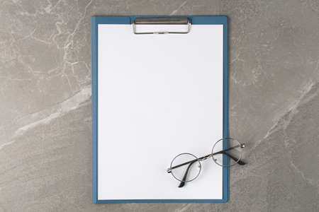 Flipboard with glasses and blank on the marble table top view,business concept