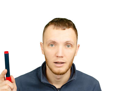 Man with marker in his hands is thoughtfully looking up on white isolated background.の写真素材