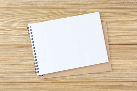Open spiral notebook on a wooden table. Design concept with copy space for notes. Blank page flat...