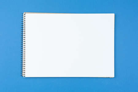 Album for drawing on a blue isolated background. Planning art work. Preparing to work on a sketch. The creative process.の写真素材