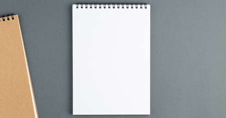 Open spiral notebook with clear page on grey background. Design business, office supplies or...
