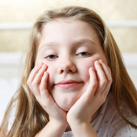 cute little girl on the bed woke up in the morning in her bed. soft white bed for a child, good mood...