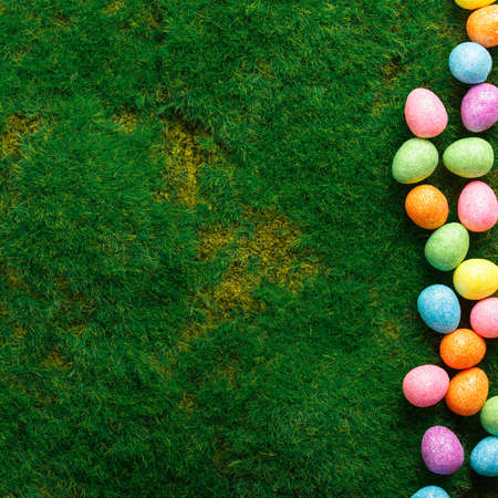 easter composition top view. colored easter eggs on green grass background flat lay with space for...