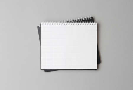 top view of a open black notebook on a gray background, school notebooks with a spiral spring,...