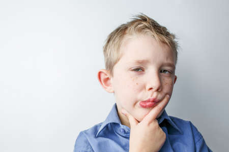 very sad little boy, the child is sad on a white background in the studioの写真素材