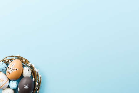 Easter background with painted eggs on a blue background top view, festive background with an open...