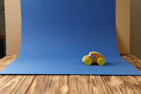 Wooden car with yellow wheels concept of environmentally friendly toys for children on a blue...