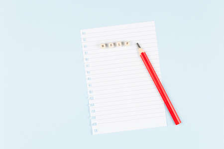 Letters collected the word help on empty sheet on blue background, symbol of helping cancer...