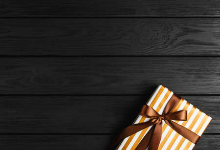 top view of a gift box on a black wooden background, gifts on a black table a flat lay, a festive conceptの写真素材
