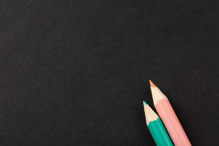 two colored pencils on a gray background top view.  schoolboy search for desired color, set for...