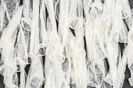 condoms on black background, flat layer, the concept of the fight against HIV and aids, the pattern...