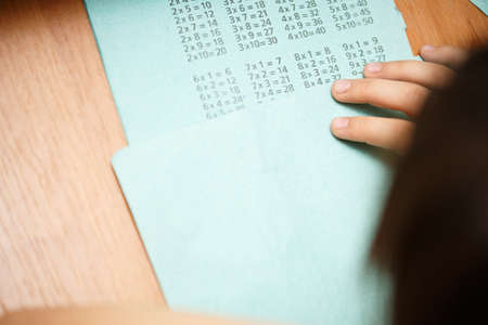 child learns the multiplication table at a desk, homework, a lesson in mathematics. independent...