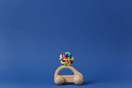 Toy made of colored rubber intertwined rings on a wooden car Concept of panoramic shooting for maps on a blue background, front view.の写真素材
