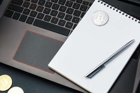 bitcoin on the keyboard, coin bitcoin on the table with the laptop, a lot of free space