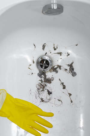 close-up dirt and hair near the drain hole in the bathroom, cleaning the sink plumberの写真素材