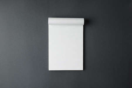 Open spiral notepad with white sheets on a gray background top view.の写真素材