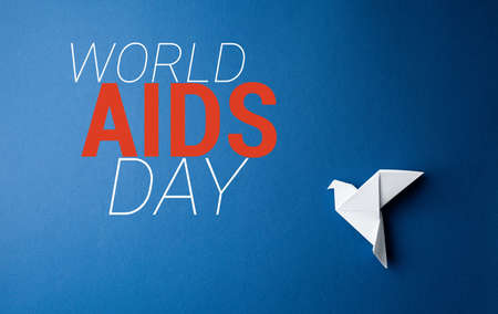 Origami pigeon on a blue isolated background.First december World AIDS Day Cancer Control concept....