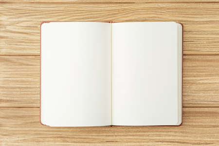 Open brown notepad on wooden background.の写真素材