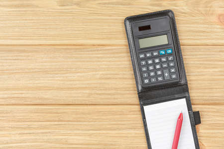Calculator with notebook in black leather bound.の写真素材