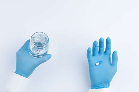 Doctor offers pills and a glass of water.