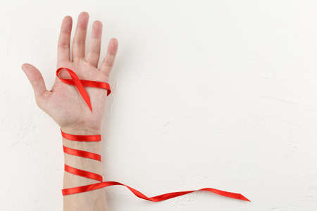Red cancer ribbon wrapped around the arm.の写真素材