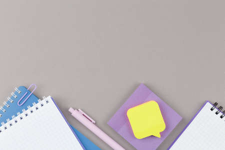 Grey school desk with educational supplies.