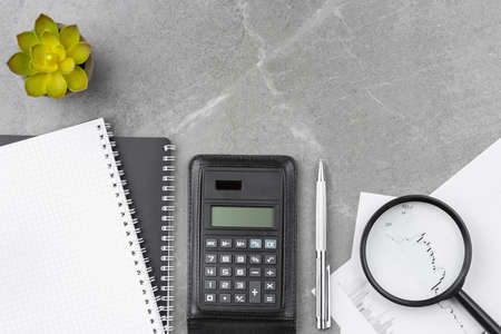 Spiral notebook with calculator on office desk.