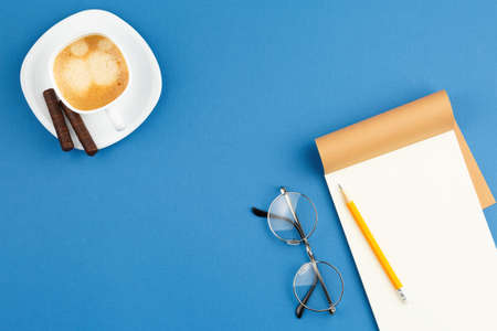 Open notepad with pencil, cup of coffee, glasses.の写真素材