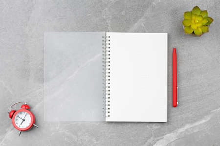Notepad with a pen on a marble background.