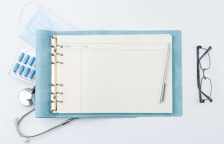 Doctor desk. Notebook with stethoscope pills.