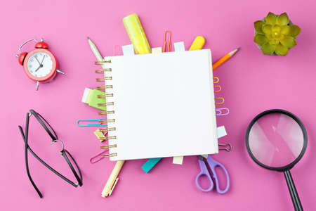 Notepad with wooden words on pink background.