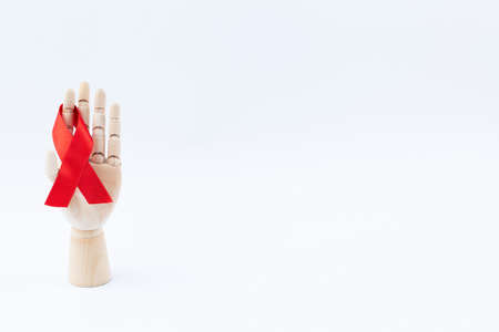Wooden hand of a mannequin with a red ribbon.