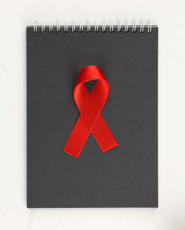 Black notepad with red ribbon as sign of cancerの写真素材