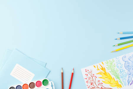 School notepad with study supplies on blue desk.の写真素材