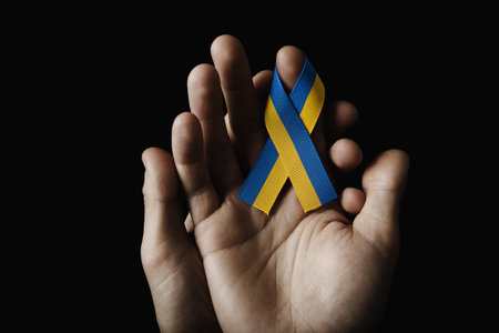 hand holding blue yellow ribbonの写真素材