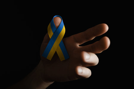 man hand holds yellow blue ribbonの写真素材