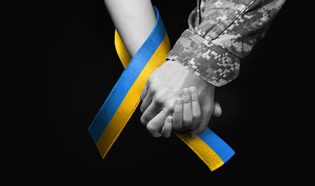 military man holds tightly hand of womanの写真素材