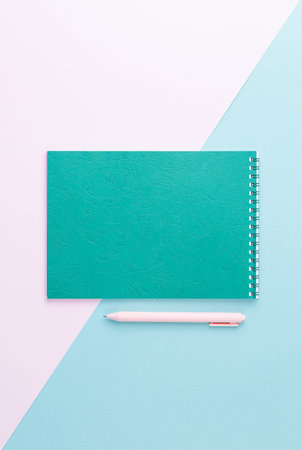Emerald spiral notebook with pink pen.の写真素材