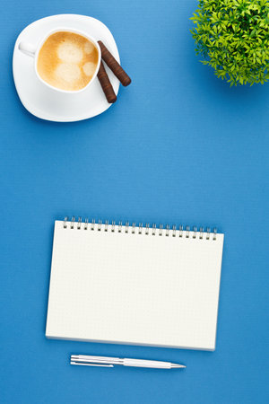 Open notepad with pen, cup of coffee and plant.の写真素材