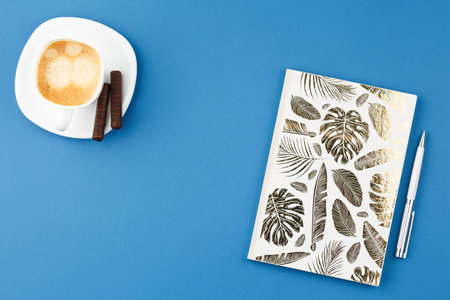 Notepad with pen and cup of coffee.の写真素材