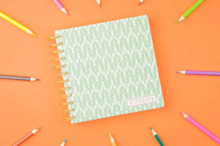 Spiral notepad with colored pencils.